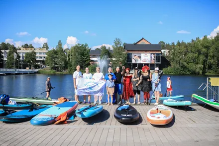 Group photo of the first SUP Festival participants holding a flag